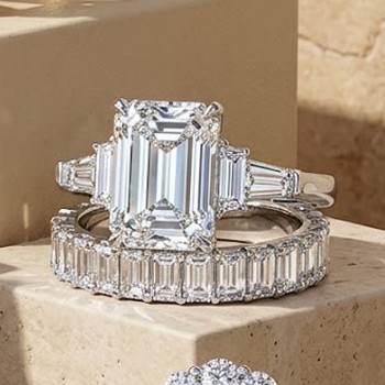 The Kew — emerald-cut three-stone engagement ring with tapered baguettes